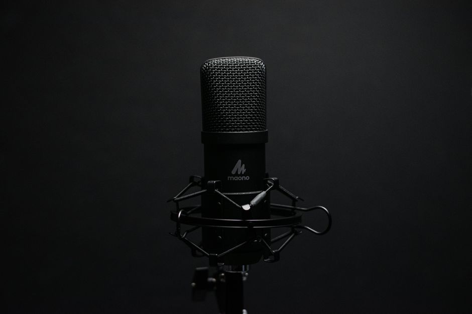 Close-up of a professional podcast microphone on a shock mount in a recording studio