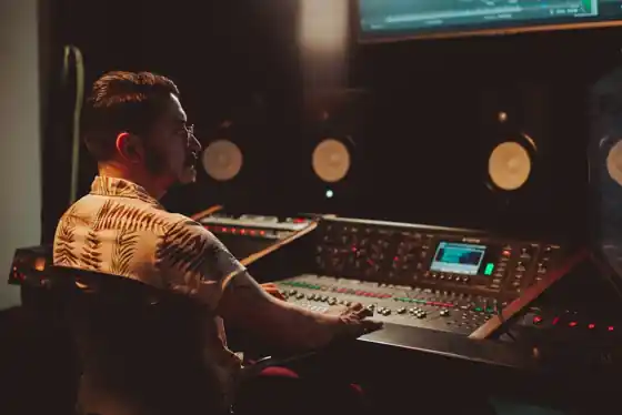Sound engineer at a mixing console with studio monitors in a Bali recording studio