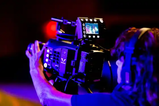 A video production crew filming on set with camera and lighting
